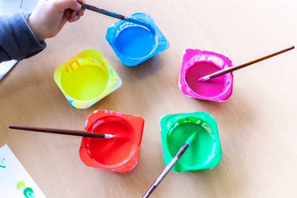 istock Child hand soaking artist brush on Washable Tempera paint 1285413033
