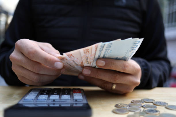 istock man doing financial transactions with calculator holding money 1285415049
