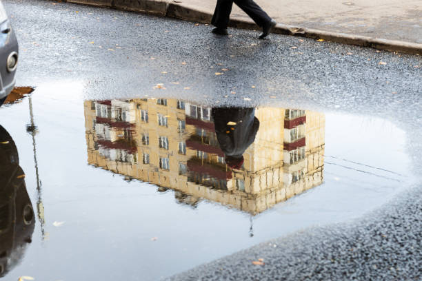 istock cityscape with puddle with reflection of house 1285415428