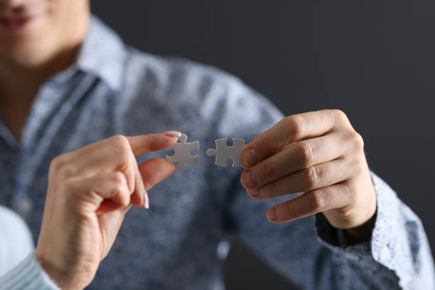 istock Mans and a womans hand connecting two puzzle pieces closeup 1285416298