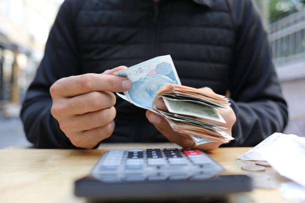 istock man doing financial transactions with calculator holding money 1285417638