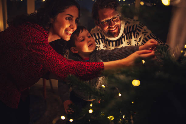 istock Small family decorating Christmas tree 1285418344