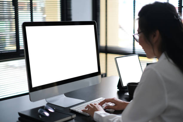 istock Side view of businesswoman is working on computer with isolated white display for your advertising text message or content business. 1285419672