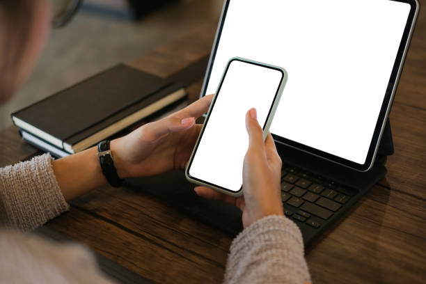 istock Cropped shot of woman hands using mobile phone and tablet computer with blank copy space screen for your advertising text message or content business. 1285419801