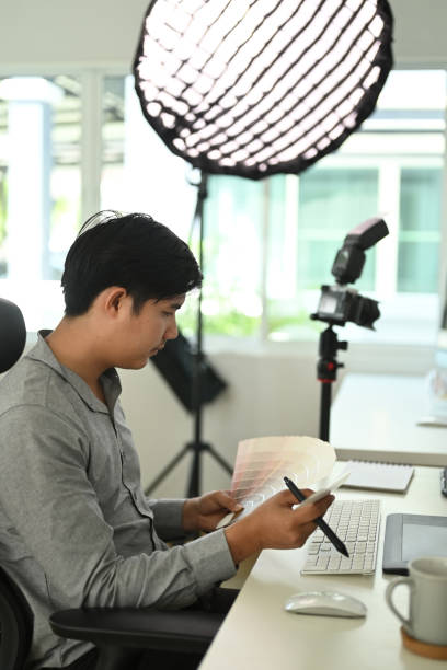 istock Side view of graphic designer or photographer is working with color samples for selection. 1285419873