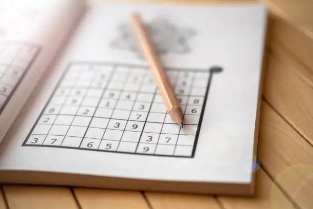 Photo of sudoku (crossword) puzzle and pencil.