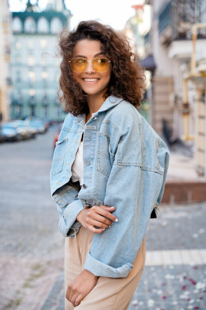 Stylish teen model posing on town streets after quarantine. Smiling stylish hispanic model in sunglasses and trendy clothes posing on town streets. street fashion stock pictures, royalty-free photos & images