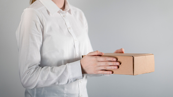 Delivery woman holding cardboard boxes/ businesswoman holding cardboard boxes.