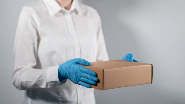 istock Delivery man holding cardboard boxes in hand,  unrecognizable person. 1285431267
