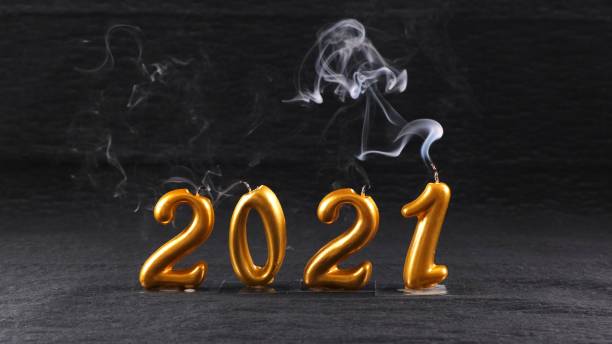 istock extinguished golden New Year 2021 candles on black background. modern concept 1285431361