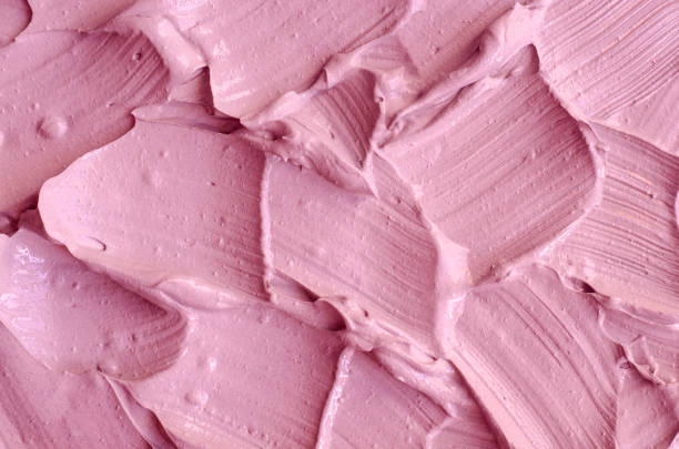 istock Pale pink cosmetic clay (alginate facial mask, face cream, body wrap) texture close up, selective focus. Abstract background with brush strokes. 1285431746