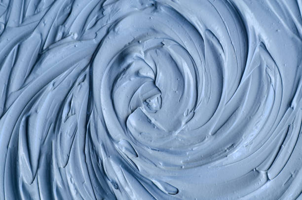 istock Light blue bentonite facial clay (alginate mask, face cream, body wrap) texture close up, selective focus. Abstract background with circle brush strokes. 1285431779