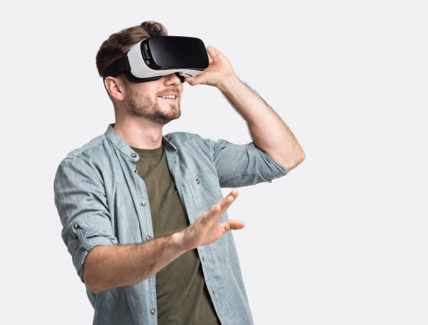 istock Young man experiencing virtual reality eyeglasses headset 1285435750