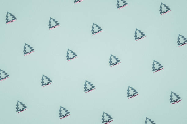 istock Rows of green flat conifer tree contour Christmas ornaments on blue surface. 1285439316