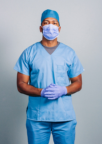Cirujano masculino con las manos entrelazadas durante coVID-19 photo