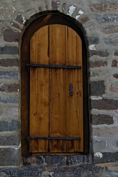 istock Old wooden door in medieval style built into a stone wall. 1285442701