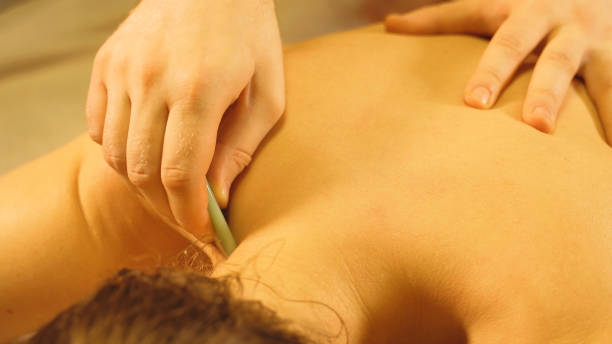 istock Massage master making gua sha massage. Spa and massage concept. 1285443855