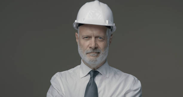 istock Confident businessman and engineer posing with a safety helmet 1285444933