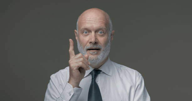 istock Cheerful businessman pointing upwards and smiling 1285445047