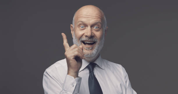 istock Cheerful businessman pointing upwards and smiling 1285446593