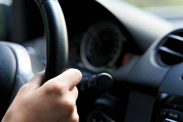 istock Female hand on steering wheel of a car while driving. 1285449796