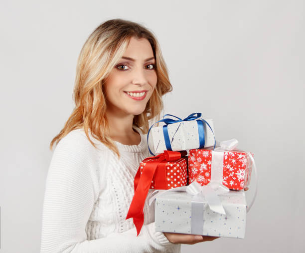 istock Smiling young woman holding wrapped presents in hands 1285450951