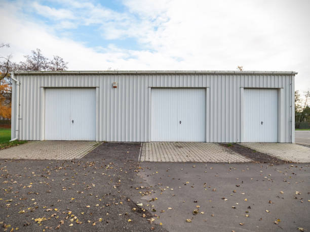 istock Garage building made of concrete with roller shutter doors. Modern building 1285451066