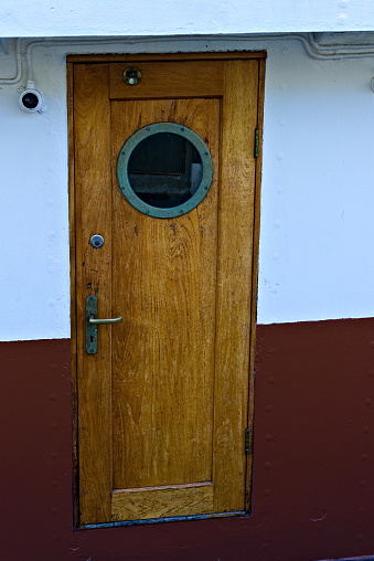 Teak boat door with a porthole.