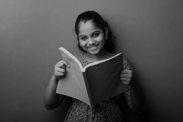 istock Happy young girl of Indian origin holding reading note book 1285455475