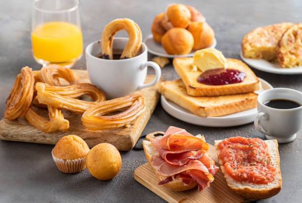Different Spanish breakfast, tortilla, bruschetta with jamon (cured ham) and tomatoes, churros with chocolate, Magdalena (Spanish cupcake) , crusty french toast with butter and jam ,coffee and orange juice. Different Spanish breakfast, tortilla, bruschetta with jamon (cured ham) and tomatoes, churros with chocolate, Magdalena (Spanish cupcake) , crusty french toast with butter and jam ,coffee and orange juice. spanish breakfast stock pictures, royalty-free photos & images