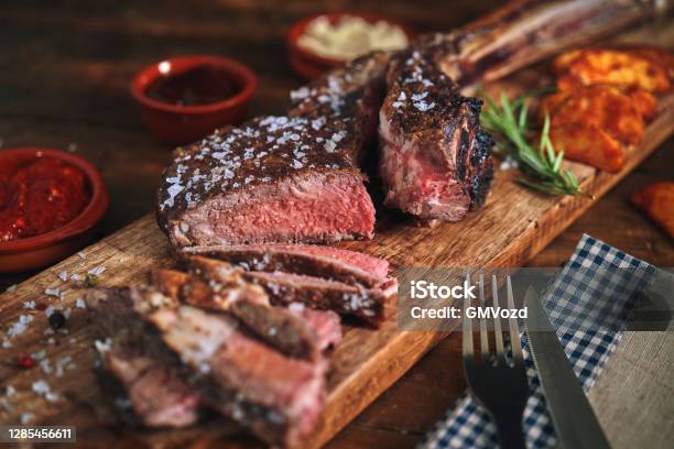 Tomahawk Steak With Country Potatoes Stock Photo - Download Image Now - Rib Eye Steak, Grilled, Bone