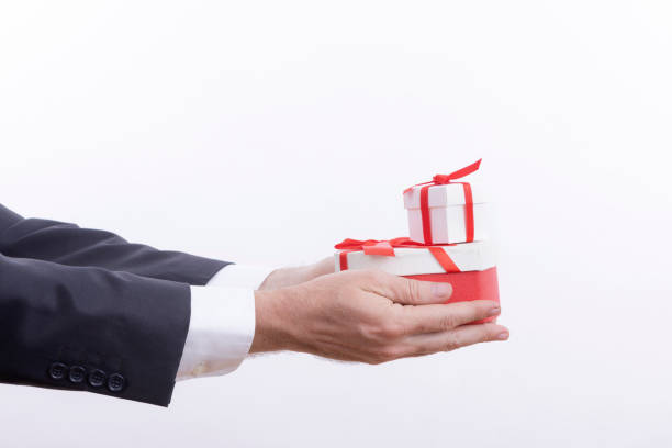 istock Businessman holding gift box on white background 1285459533