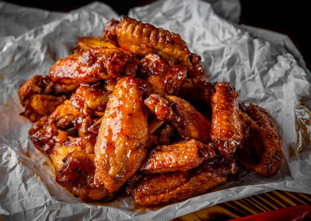 asas de frango frito com molho de pimenta doce em papel branco - wing chicken barbecue grilled - fotografias e filmes do acervo