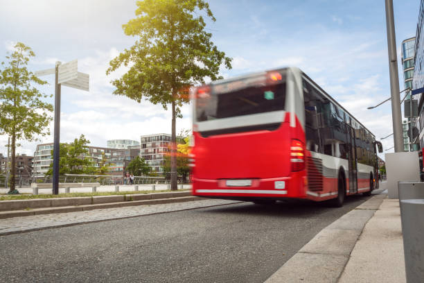 ônibus passando em uma rua no entorno urbano - red bus - fotografias e filmes do acervo