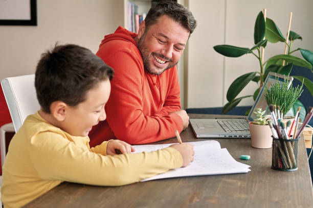istock Father helping his son for homework at home. 1285465661