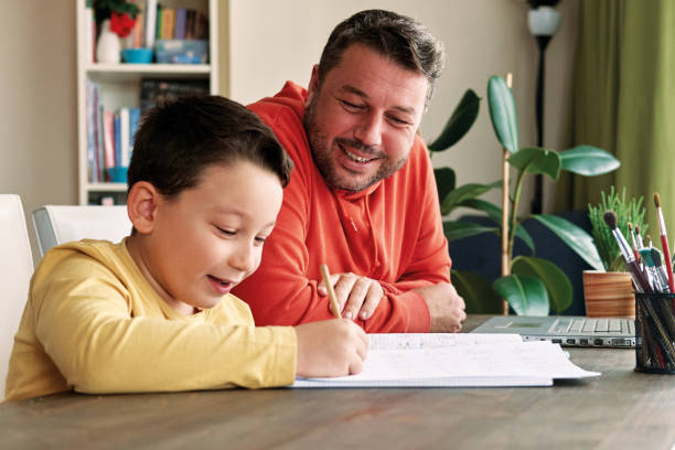 istock Father helping his son for homework at home. 1285466249