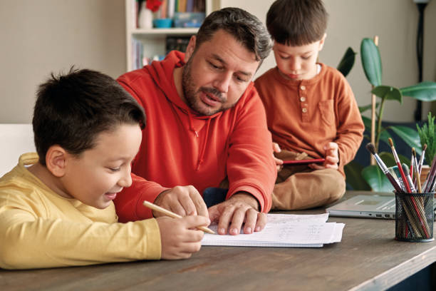 istock Father helping his son for homework at home. 1285466313