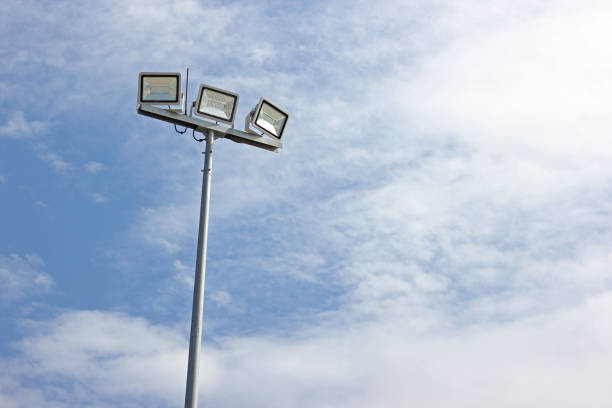 Spotlight pole, Power poles and sport light with blue sky and clouds background.
