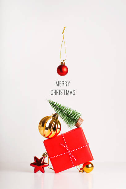 Decoration of gift, balls, Christmas tree on white background. Simplicity Sparse still life balance in red, gold and green. minimal Template mockup for new year card