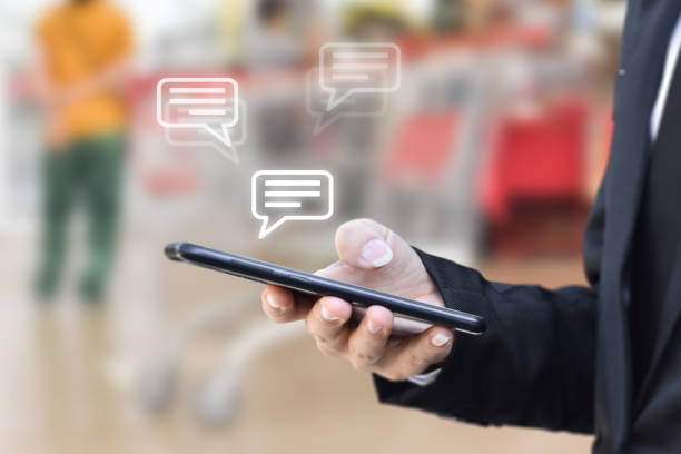 istock Businessman hand using mobile phone typing, with chat icons. 1285467019