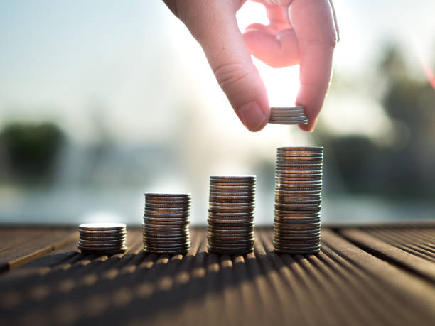 Hand putting money coins stack growing, saving money for purpose concept