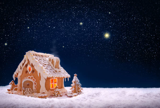 Gingerbread house on the white snow isolated on night sky stock photo