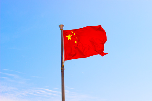 Flag of China in sky. Hainan island, China. Selective focus