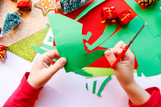 istock Kid playing with christmas crafts on white background. Christmas celebration. White background. Happy cheerful family. Home decoration. Christmas present. 1285471379