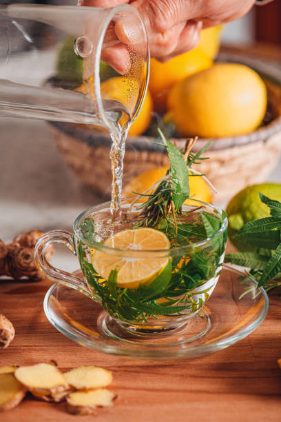 preparación de té de hierbas con limón en la mesa de madera - ginger tea cup cold and flu tea fotografías e imágenes de stock