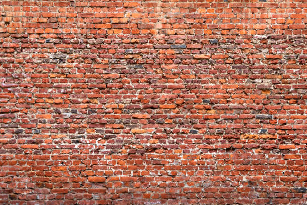 istock Brick wall made of old crumbling red bricks 1285475572