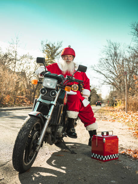 Santa Claus taking a break from riding a motor bike along the quiet residential street in suburbia.