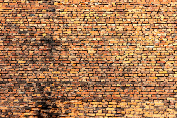 istock Brick wall made of old crumbling red bricks 1285475686