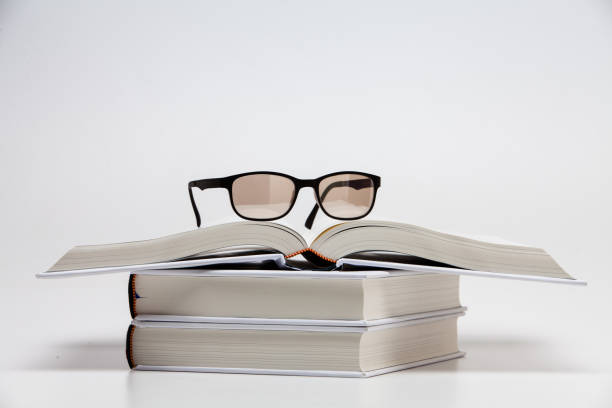 istock Open book and glasses on white background 1285476504