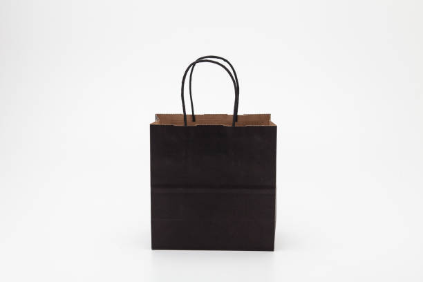 istock Empty black paper shopping bag on white 1285477784